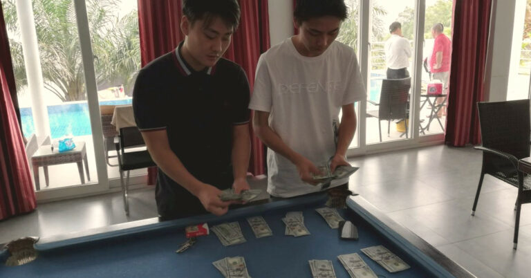 Zwei Chinesen zählen Dollarnoten.