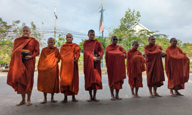 Buddhistische Mönche auf ihrer Almosenrunde in Kep, Kambodscha.