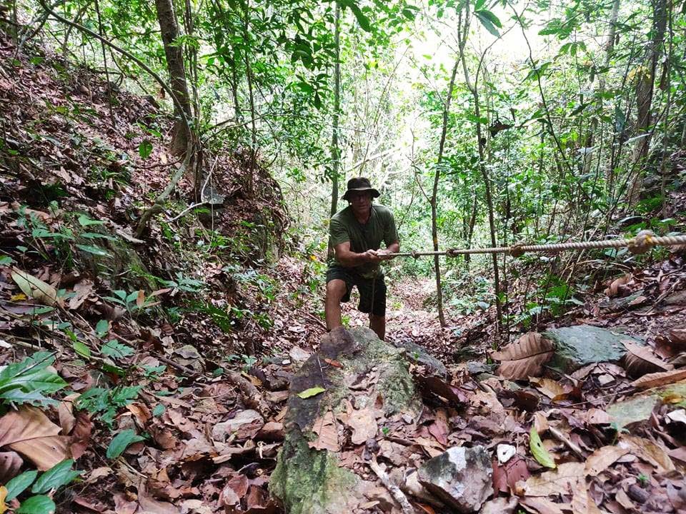 Andreas zieht sich bei einer Dschungel-Tour im Kep-Nationalpark an einem Seil einen Abhang hoch.